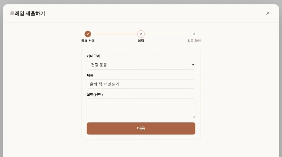 트레일 제출 화면의 3단계 위저드. 1단계(목표 선택)는 완료 표시되어 있고, 2단계(입력)에서 카테고리·제목·설명을 채우는 모습
